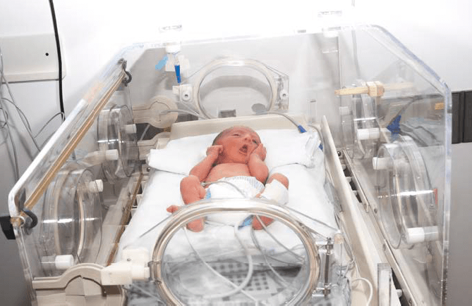 infant in NICU ward incubator